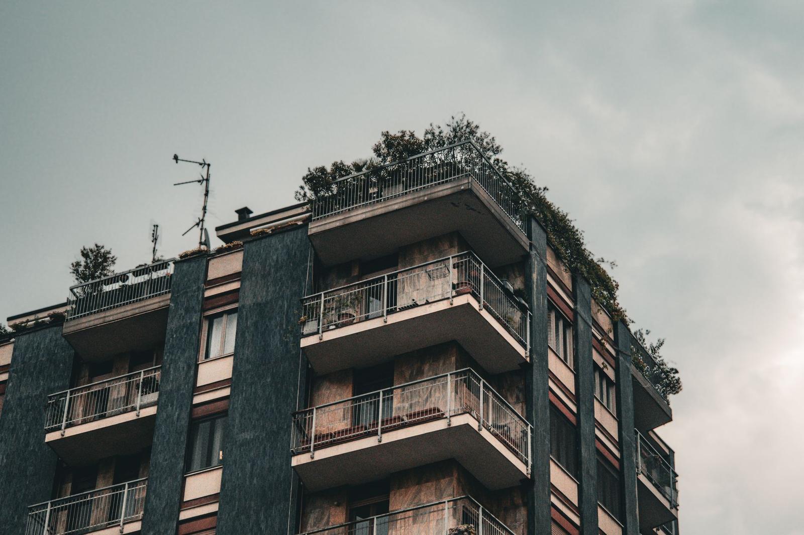 An Apartment Building with Balconies and Plants on the Roof